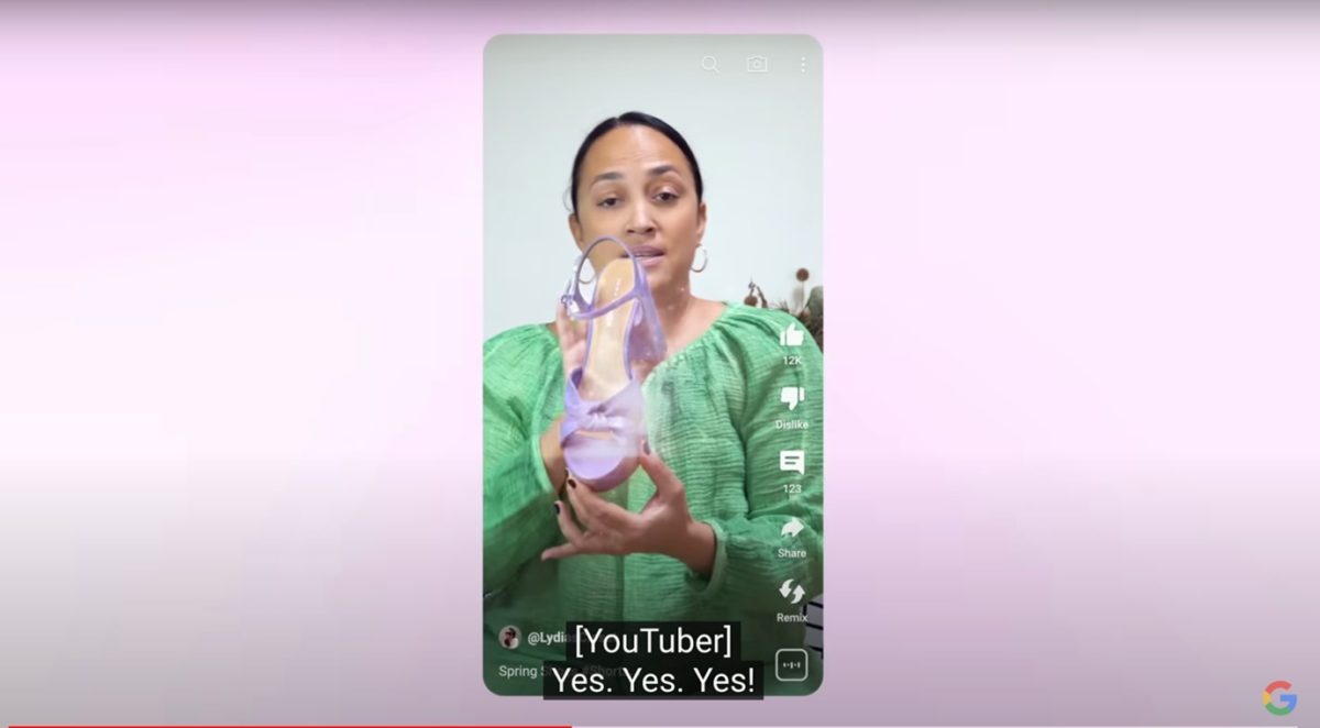 Screenshot of a woman holding up a shoe with the caption '[YouTuber] Yes. Yes. Yes!' underneath.