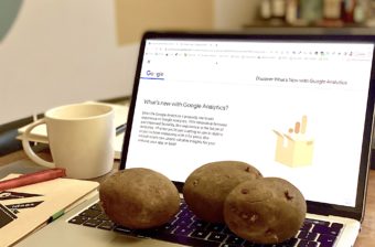 An open laptop with 3 potatoes on the keyboard and Google Analytics displayed on the screen.